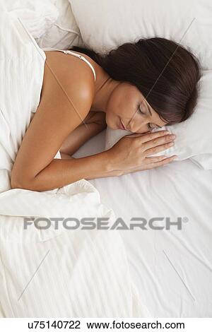 Stock Image - USA, Illinois, Metamora, young woman sleeping in bed. Fotosearch