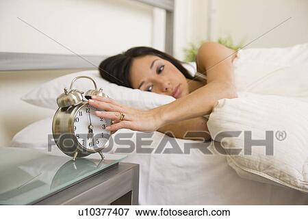 USA, Illinois, Metamora, Young woman turning off alarm clock View Large Photo Image Stock Photo - USA, Illinois, Metamora, Young woman turning off alarm clock. Fotosearch