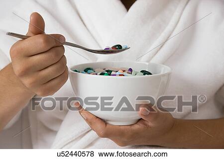 USA, Illinois, Metamora, Young woman eating pills from bowl View Large Photo Image Stock Photo - USA, Illinois, Metamora, Young woman eating pills from bowl. Fotosearch