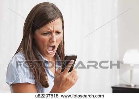 USA, Illinois, Metamora, young woman shouting to mobile phone View Large Photo Image Stock Photo - USA, Illinois, Metamora, young woman shouting to mobile phone. Fotosearch