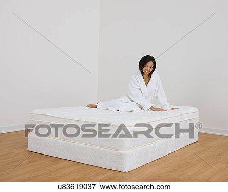 USA, Illinois, Metamora, Young woman sitting on mattress View Large Photo Image Stock Photo - USA, Illinois, Metamora, Young woman sitting on mattress. Fotosearch