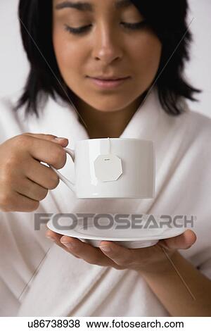 USA, Illinois, Metamora, Young woman holding tea cup View Large Photo Image Stock Photo - USA, Illinois, Metamora, Young woman holding tea cup. Fotosearch