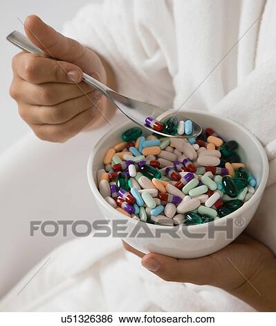 USA, Illinois, Metamora, Young woman eating pills from bowl View Large Photo Image Stock Photograph - USA, Illinois, Metamora, Young woman eating pills from bowl. Fotosearch