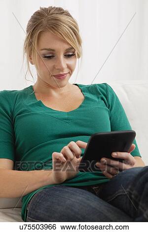 Stock Photograph - USA, Illinois, Metamora, Young woman using tablet pc. Fotosearch