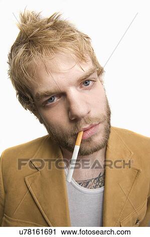 USA, Illinois, Peoria, Studio portrait of young man with cigarette in mouth View Large Photo Image Stock Image - USA, Illinois, Peoria, Studio portrait of young man with cigarette in mouth. Fotosearch