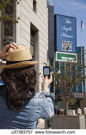 Stock Photo - USA, Illinois, Peoria, Woman taking photo with smart phone. Fotosearch