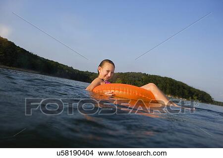 USA, Missouri, Stockton, Stockton Lake, girl (8-9) swimming in inflatable ring View Large Photo Image Picture - USA, Missouri, Stockton, Stockton Lake, girl (8-9) swimming in inflatable ring. Fotosearch