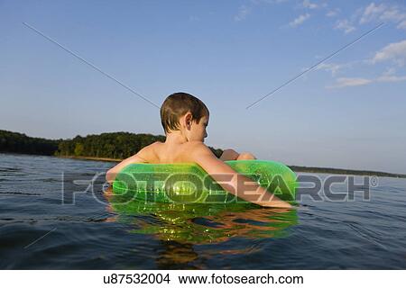 Picture - USA, Missouri, Stockton, Stockton Lake, boy (6-7) swimming in inflatable ring. Fotosearch