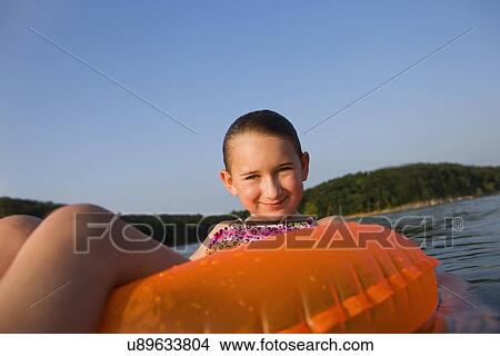 USA, Missouri, Stockton, Stockton Lake, girl (8-9) swimming in inflatable ring View Large Photo Image Picture - USA, Missouri, Stockton, Stockton Lake, girl (8-9) swimming in inflatable ring. Fotosearch