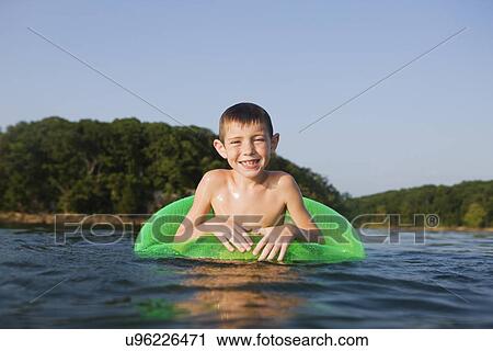 Stock Image - USA, Missouri, Stockton, Stockton Lake, boy (6-7) swimming in inflatable ring. Fotosearch