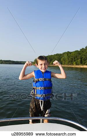 USA, Missouri, Stockton, Stockton Lake, boy (6-7) wearing lifejacket flexing muscles View Large Photo Image Stock Photo - USA, Missouri, Stockton, Stockton Lake, boy (6-7) wearing lifejacket flexing muscles. Fotosearch