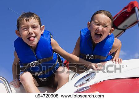 USA, Missouri, Stockton, Stockton Lake, boy (6-7) and girl (8-9) on boat making faces View Large Photo Image Stock Photo - USA, Missouri, Stockton, Stockton Lake, boy (6-7) and girl (8-9) on boat making faces. Fotosearch