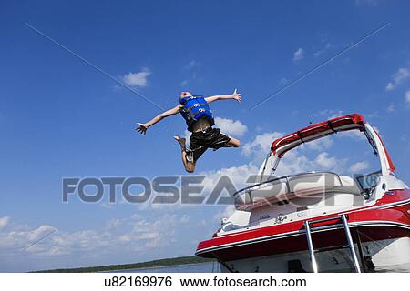 USA, Missouri, Stockton, Stockton Lake, boy (6-7) jumping off boat View Large Photo Image Stock Photograph - USA, Missouri, Stockton, Stockton Lake, boy (6-7) jumping off boat. Fotosearch
