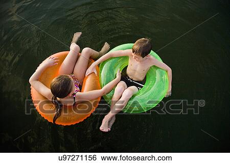 USA, Missouri, Stockton, Stockton Lake, boy (6-7) and girl (8-9) swimming in inflatable rings View Large Photo Image Stock Photograph - USA, Missouri, Stockton, Stockton Lake, boy (6-7) and girl (8-9) swimming in inflatable rings. Fotosearch