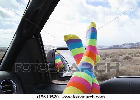 Stock Image - USA, New Mexico, Girl (10-11) with feet out of car window, wearing striped socks. Fotosearch