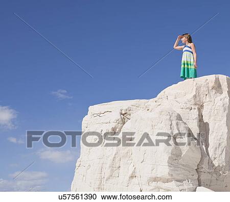 Stock Image - USA, New Mexico, Whitesands, Girl (10-11) standing on rock and looking away. Fotosearch