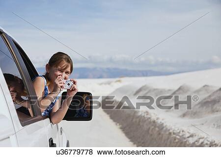 Stock Photo - USA, New Mexico, Whitesands, Girl (10-11) taking photo from car. Fotosearch