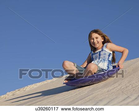 USA, New Mexico, Whitesands, Girl (10-11) sliding down sand dune View Large Photo Image Stock Photo - USA, New Mexico, Whitesands, Girl (10-11) sliding down sand dune. Fotosearch