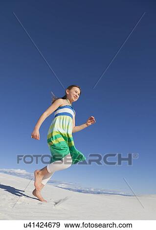 Stock Photo - USA, New Mexico, Whitesands, Girl (10-11) running on desert. Fotosearch