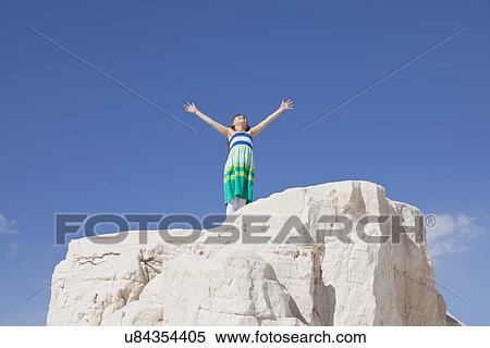 Stock Photography - USA, New Mexico, Whitesands, Girl (10-11) standing on rock. Fotosearch