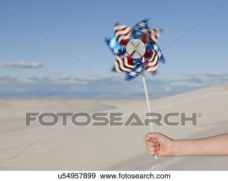 Stock Photo - USA, New Mexico, Whitesands, Girl's hand with pinwheel. Fotosearch