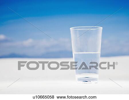 Stock Photo - USA, New Mexico, Whitesands, Glass of water on desert. Fotosearch