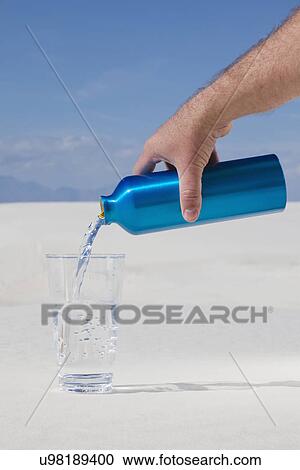 USA, New Mexico, Whitesands, Man pouring water from blue thermos on desert View Large Photo Image Stock Image - USA, New Mexico, Whitesands, Man pouring water from blue thermos on desert. Fotosearch
