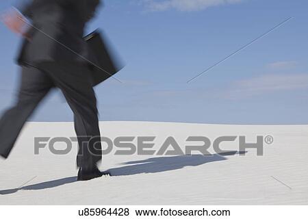 USA, New Mexico, Whitesands, Man wearing suit walking on desert View Large Photo Image Stock Photo - USA, New Mexico, Whitesands, Man wearing suit walking on desert. Fotosearch