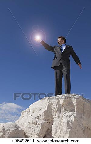Stock Image - USA, New Mexico, Whitesands, Businessman holding source of light. Fotosearch