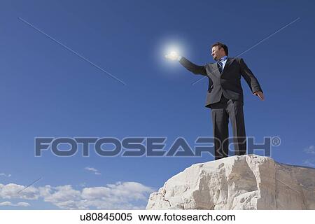 USA, New Mexico, Whitesands, Businessman holding source of light View Large Photo Image Stock Photography - USA, New Mexico, Whitesands, Businessman holding source of light. Fotosearch