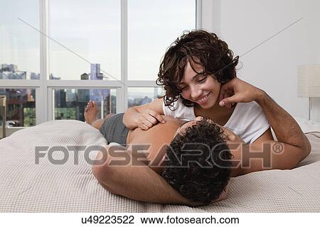 USA, New York City, couple embracing on bed View Large Photo Image Stock Image - USA, New York City, couple embracing on bed. Fotosearch