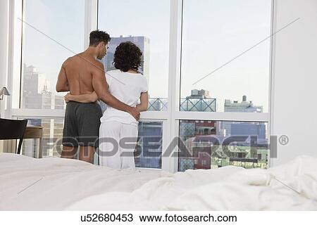 USA, New York City, couple looking out bedroom window View Large Photo Image Stock Image - USA, New York City, couple looking out bedroom window. Fotosearch