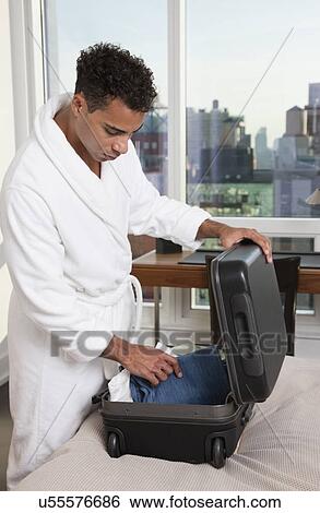 USA, New York City, man in bedroom packing suitcase View Large Photo Image Stock Photograph - USA, New York City, man in bedroom packing suitcase. Fotosearch