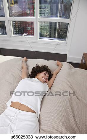USA, New York City, woman stretching on bed View Large Photo Image Stock Photo - USA, New York City, woman stretching on bed. Fotosearch