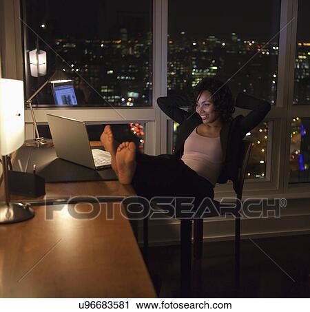 Stock Image - USA, New York City, woman using laptop in bedroom. Fotosearch