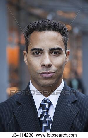 Stock Image - USA, New York, New York City, portrait of smiling businessman on street. Fotosearch