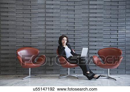 USA, New York, New York City, portrait of smiling young woman using laptop in hotel lobby View Large Photo Image Stock Image - USA, New York, New York City, portrait of smiling young woman using laptop in hotel lobby. Fotosearch