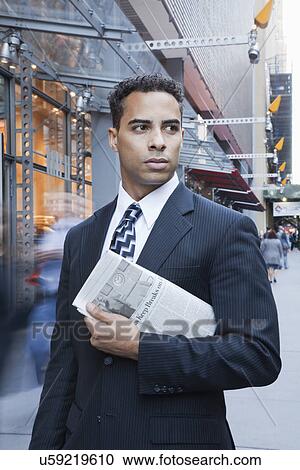 Stock Image - USA, New York, New York City, portrait of smiling businessman on street. Fotosearch