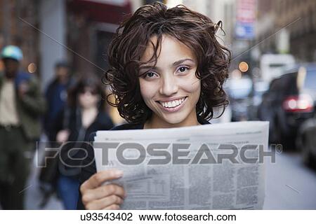 USA, New York, New York City, portrait of smiling woman holding newspaper on street View Large Photo Image Stock Image - USA, New York, New York City, portrait of smiling woman holding newspaper on street. Fotosearch