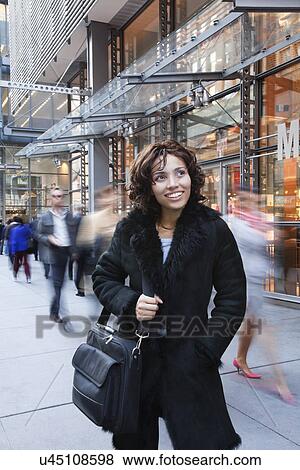 Stock Photo - USA, New York, New York City, portrait of smiling woman on street. Fotosearch