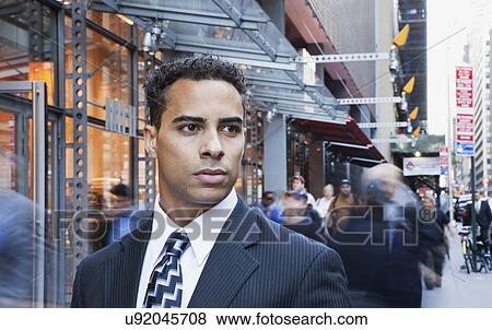 Stock Photo - USA, New York, New York City, portrait of smiling businessman on street. Fotosearch