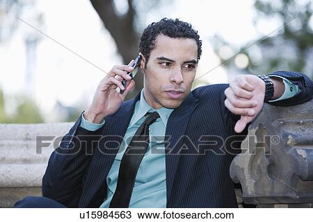 USA, New York, New York City, Businessman with cell phone checking watch View Large Photo Image Stock Image - USA, New York, New York City, Businessman with cell phone checking watch. Fotosearch