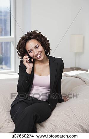 USA, New York State, New York City, business woman using mobile phone on bed View Large Photo Image Picture - USA, New York State, New York City, business woman using mobile phone on bed. Fotosearch