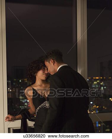 Stock Image - USA, New York State, New York City, young couple face to face by window. Fotosearch