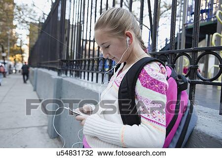 Stock Image - USA, New York State, New York City, Girl (10-11) with earphones listening music . Fotosearch