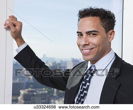 Stock Photo - USA, New York State, New York City, portrait of business man by window. Fotosearch
