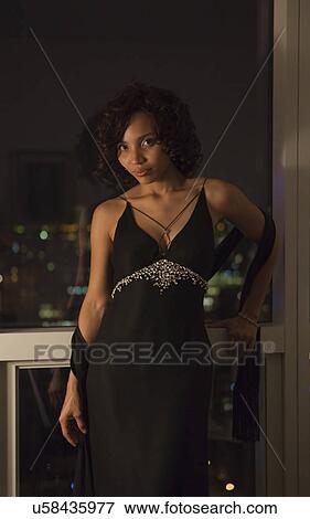USA, New York State, New York City, portrait of young woman wearing dress by window View Large Photo Image Stock Photo - USA, New York State, New York City, portrait of young woman wearing dress by window. Fotosearch