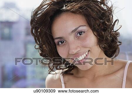 Stock Photo - USA, New York State, New York City, portrait of young woman smiling. Fotosearch