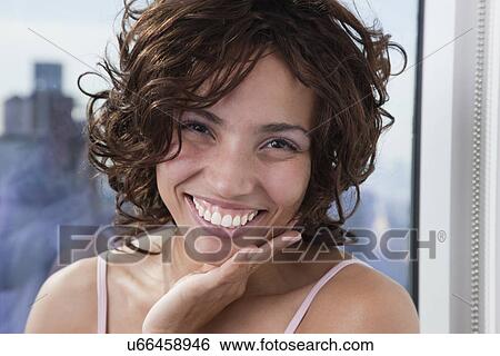 Stock Photograph - USA, New York State, New York City, portrait of young woman smiling. Fotosearch