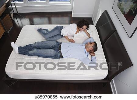 USA, New York State, New York City, young couple lying on bed View Large Photo Image Stock Photography - USA, New York State, New York City, young couple lying on bed. Fotosearch